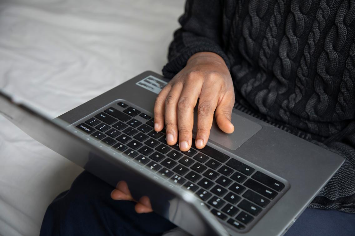 Photo of a hand typing on a laptop