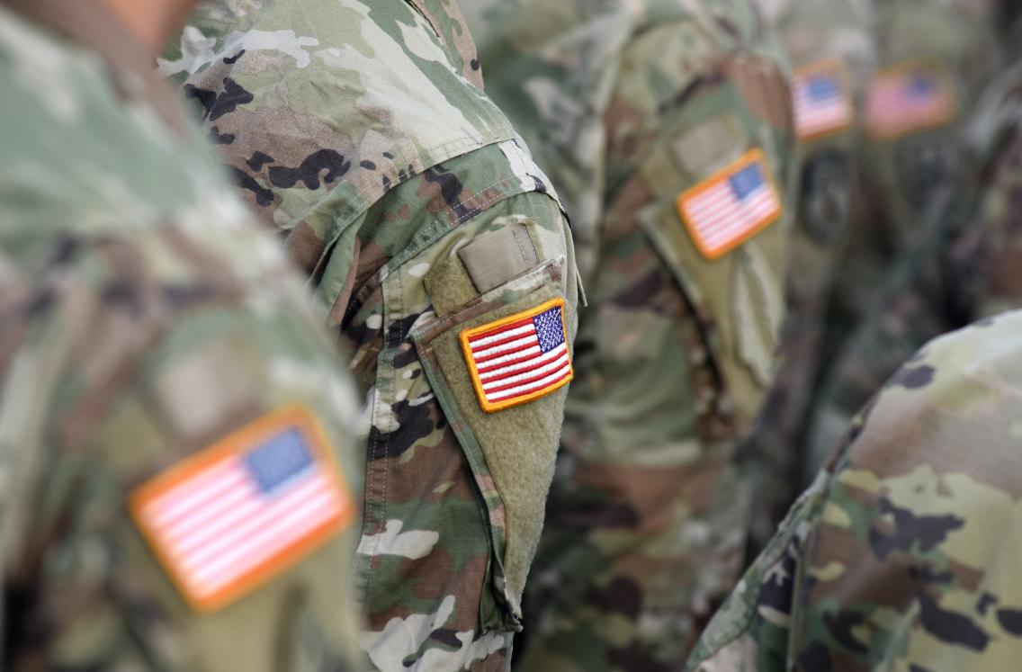 line of people in camo with US flag patch