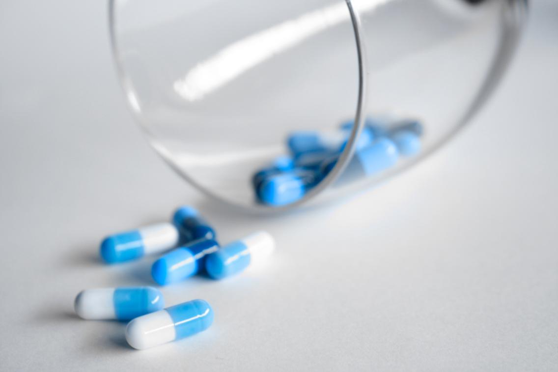 antibiotic capsules coming out of glass onto counter